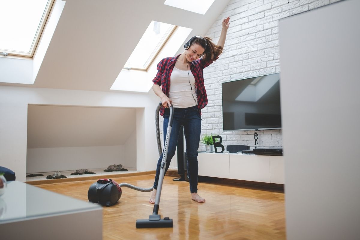 Mulher limpando a casa feliz fonte: Canva
